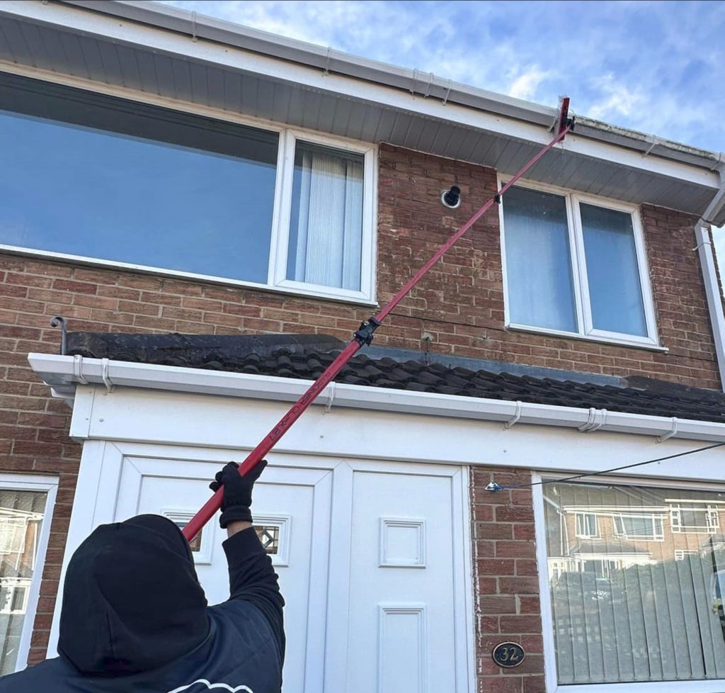 Image of a person cleaning fascias